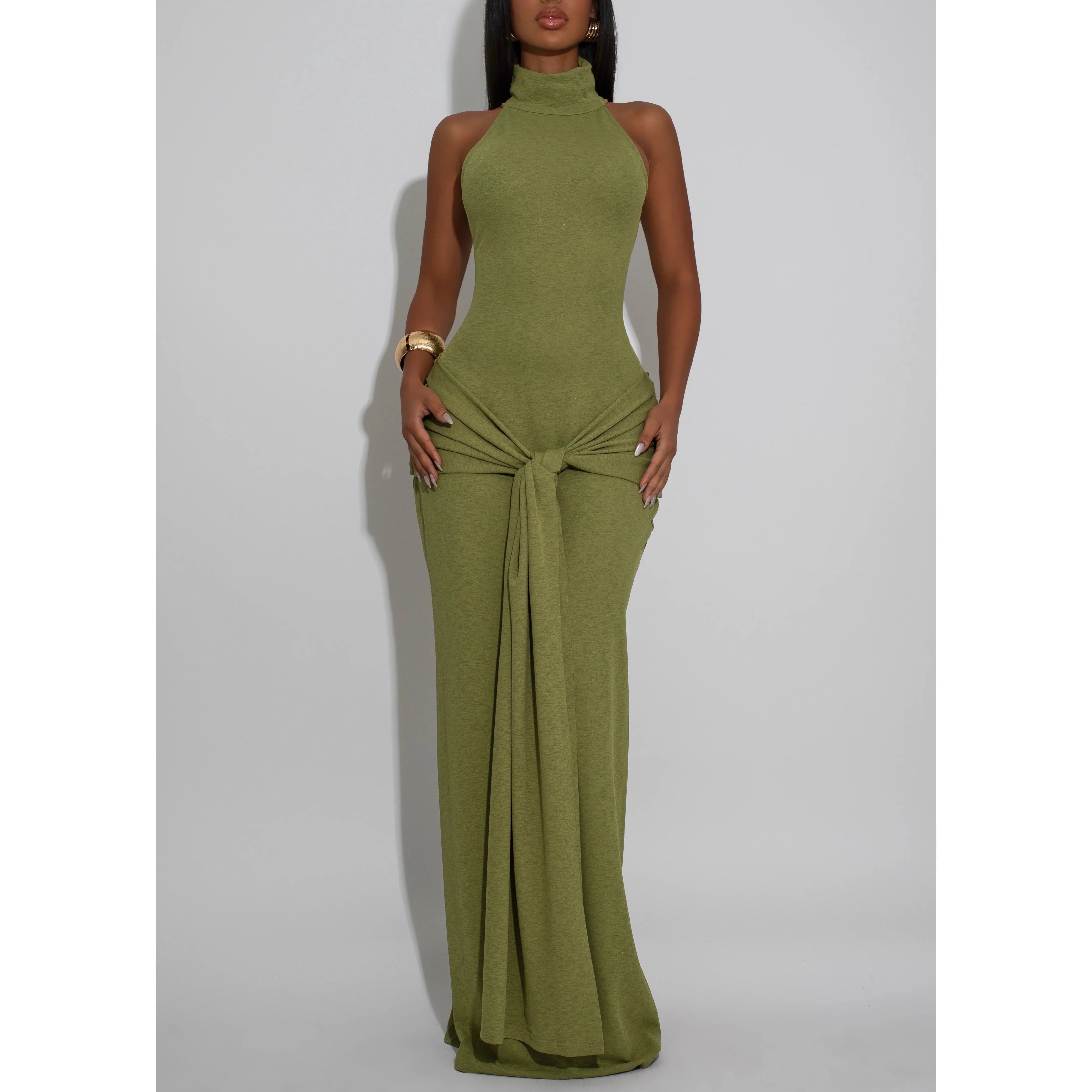 Woman wearing a mock neck sleeveless green halter neck maxi dress with front tie draping detail.  