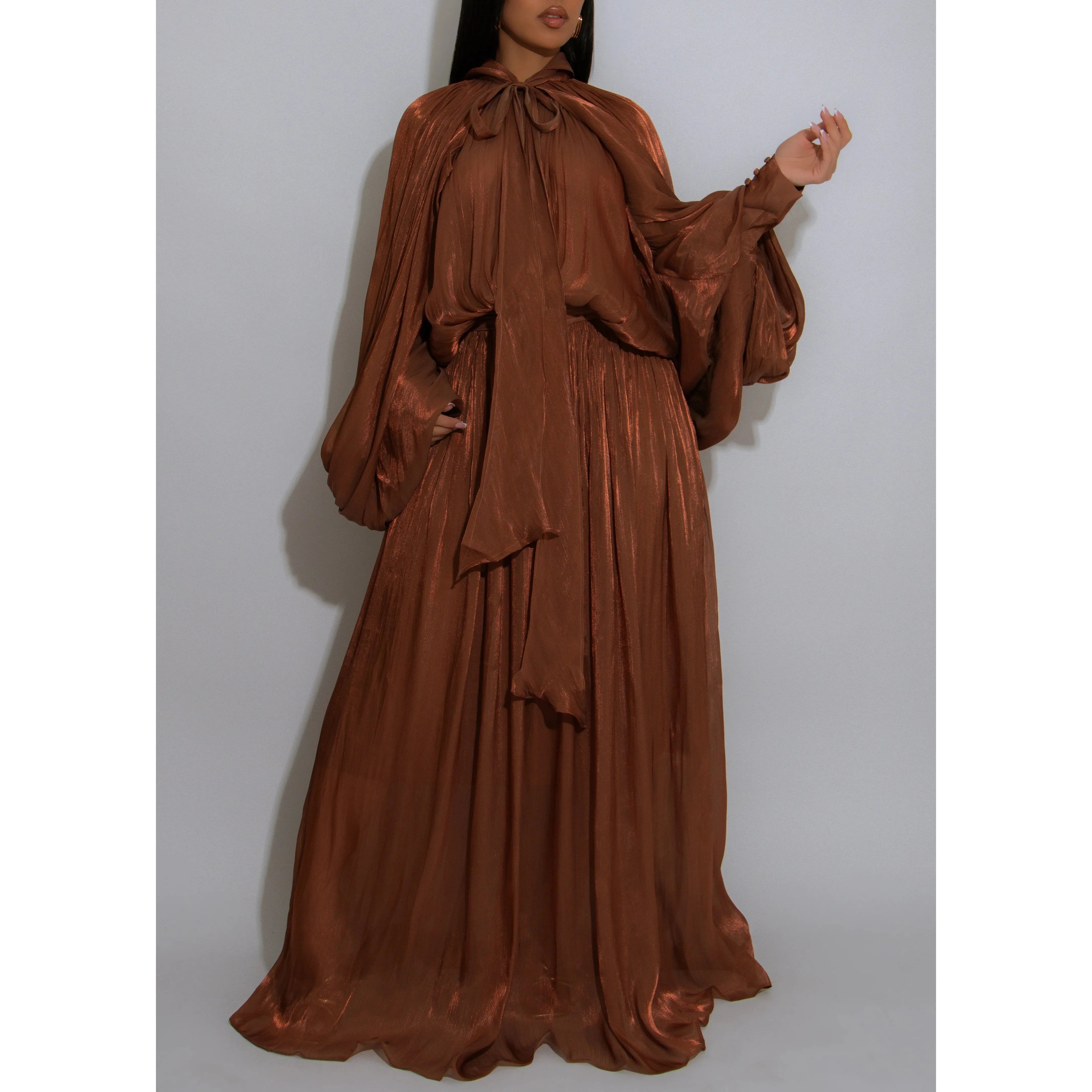 Shimmery cinnamon hue maxi gown with  pussy bow neck tie dramatic balloon sleeves and sophisticated pleats and a cascading skirt 