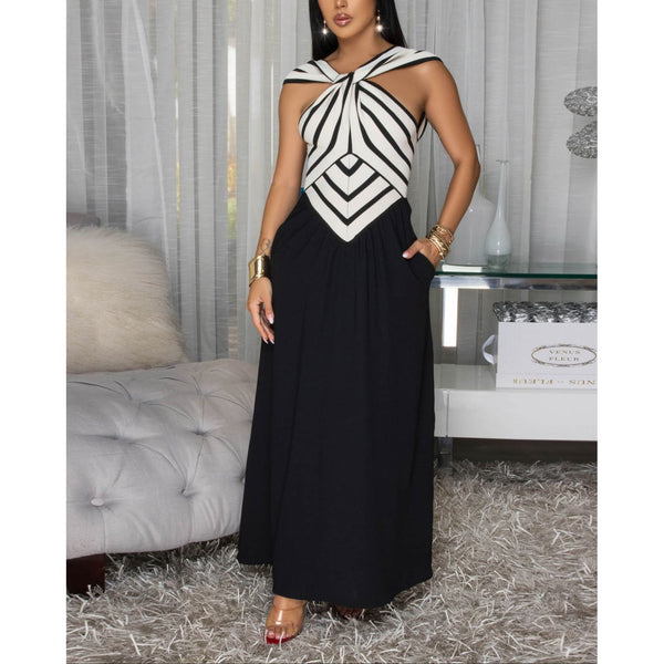 Woman wearing sleeveless knit bodice maxi dress featuring a refined halter neckline and striking striped bodice, a playful flowy black skirt w/ side pockets . 