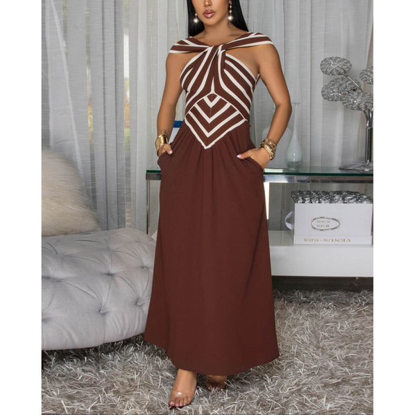 Woman wearing sleeveless knit bodice maxi dress featuring a refined halter neckline and striking brown and cream striped bodice, a playful flowy black skirt w/ side pockets .