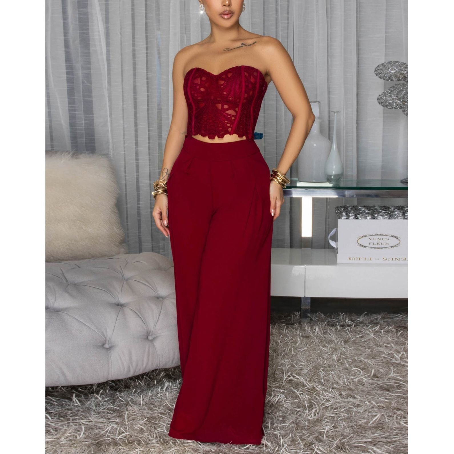 Woman wearing a Burgundy eyelet Lace Corset Top with matching complementary elegant Wide-Leg Pants. 