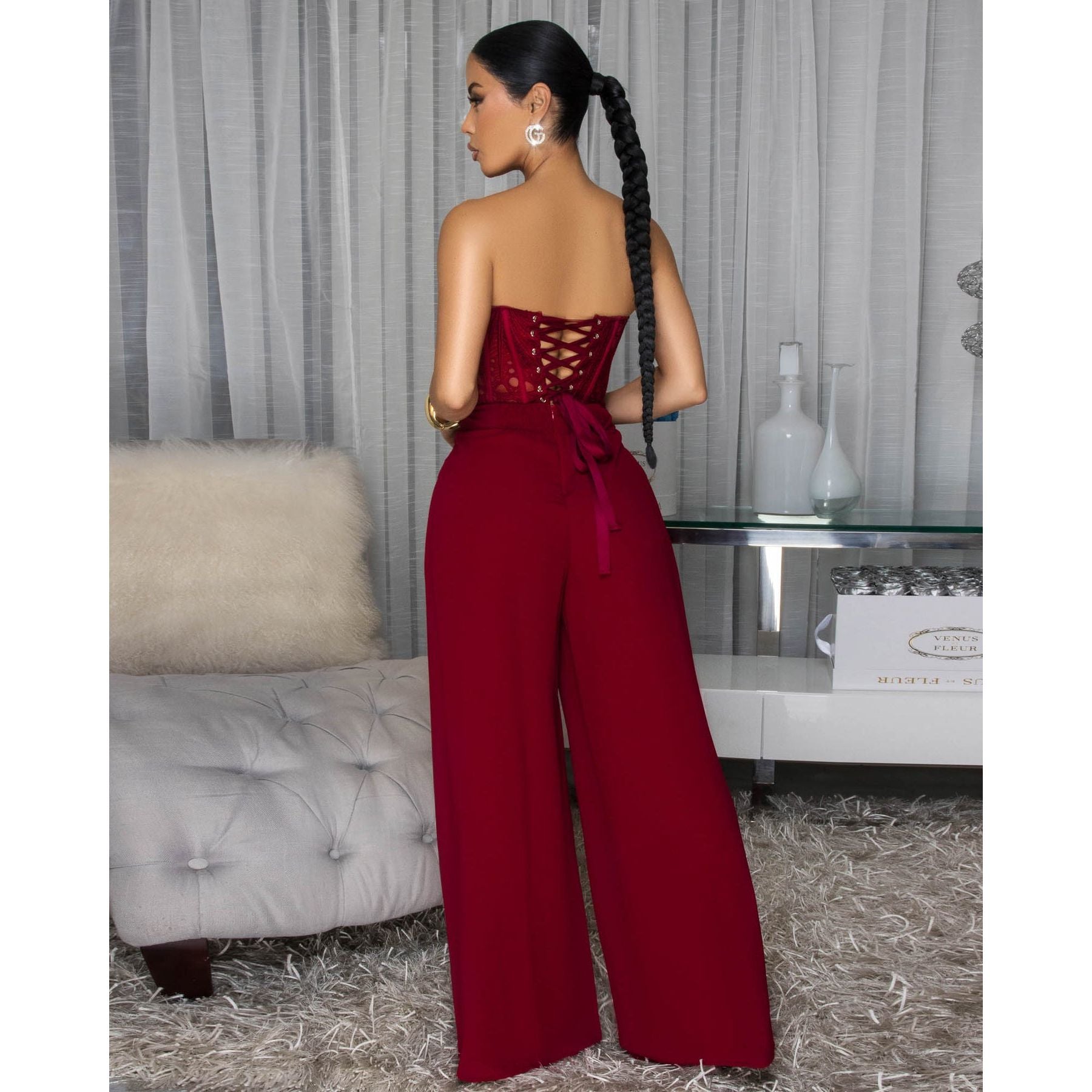 Woman wearing a Burgundy Eyelet Lace Corset Top with matching complementary elegant Wide-Leg Pants.  Corset Top Has Lace Up Closure 