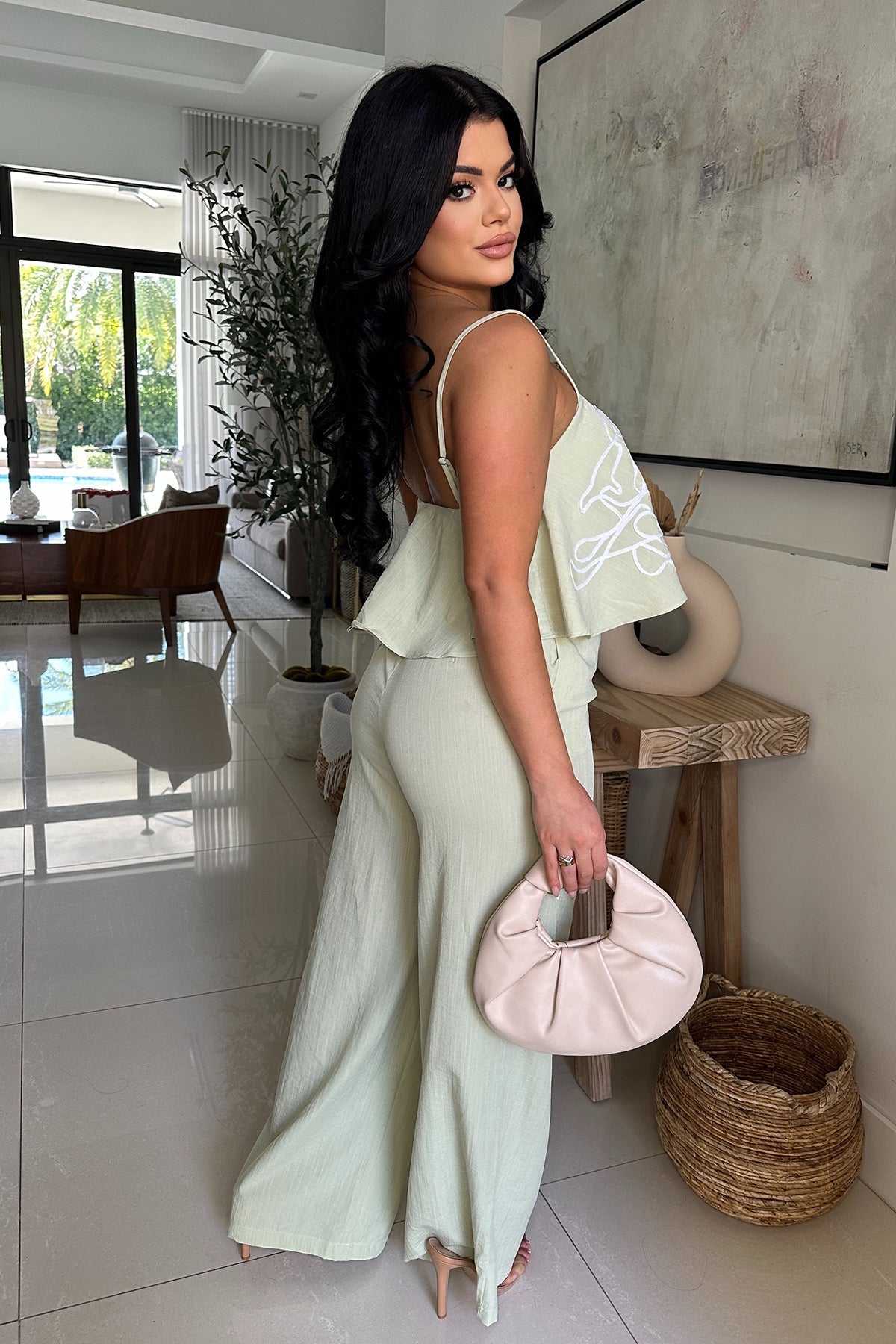 Sage green pant set with breezy flounce top with white embroidery detail , adjustable straps and tailored high waisted wide leg pants with zipper closure